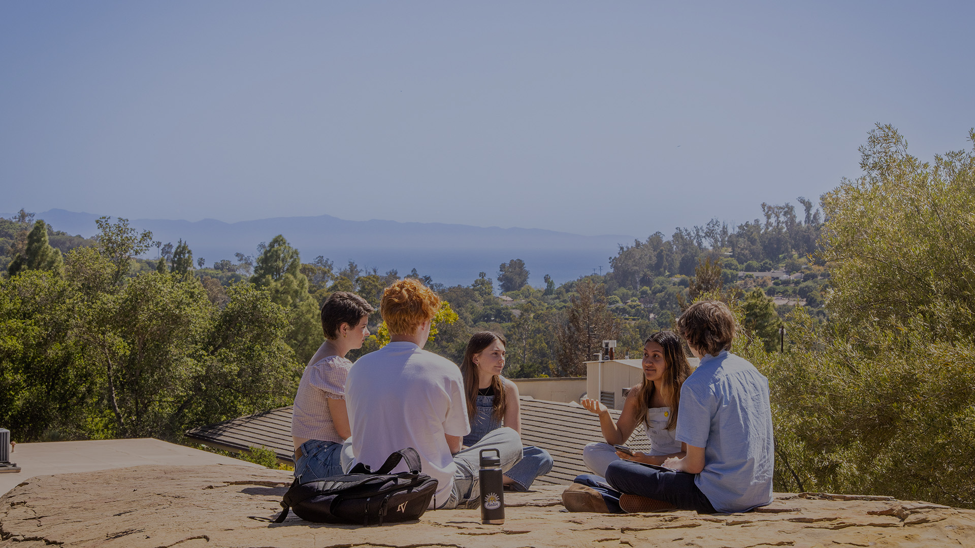 students sitting on a rock first year page