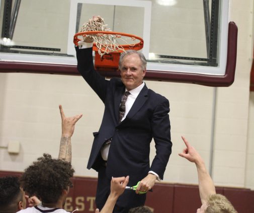 Head Coach John Moore cuts the net