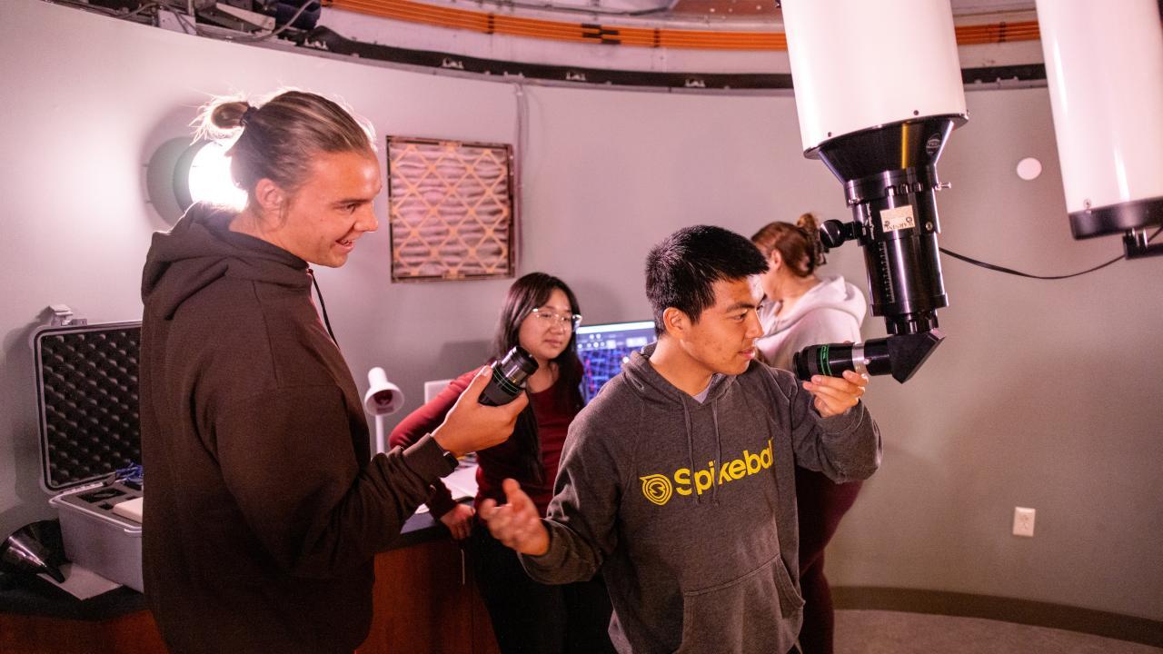 Astrophysics Minor student looking through telescope